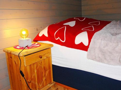 Una cama con una manta roja y una vela en una mesita de noche en Holiday home Kokelv II, en Kokelv