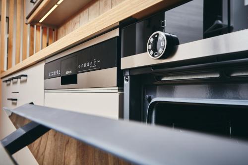 a kitchen with an oven with a clock on it at HOMEBOUND APARTMENTS Bad Goisern - contactless check-in in Bad Goisern