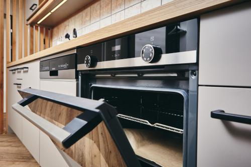a kitchen with a black and white oven at HOMEBOUND APARTMENTS Bad Goisern - contactless check-in in Bad Goisern
