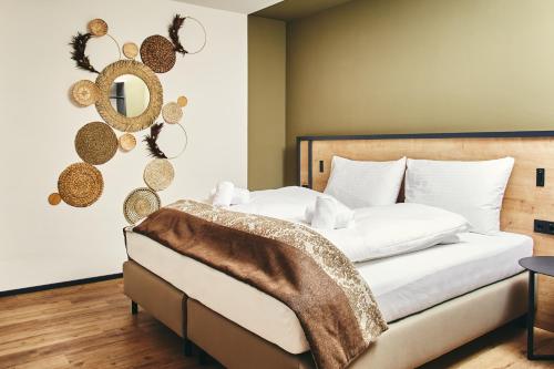a bedroom with a bed and a mirror on the wall at HOMEBOUND APARTMENTS Bad Goisern - contactless check-in in Bad Goisern