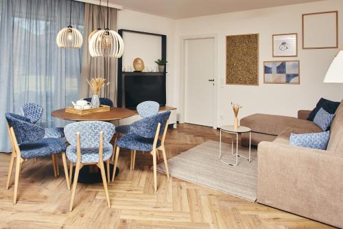 a living room with a table and chairs and a couch at HOMEBOUND APARTMENTS Bad Goisern - contactless check-in in Bad Goisern