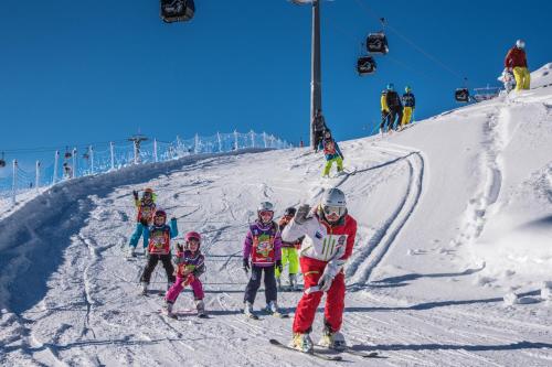 a group of people skiing down a snow covered slope at Hotel Falken in Falzes