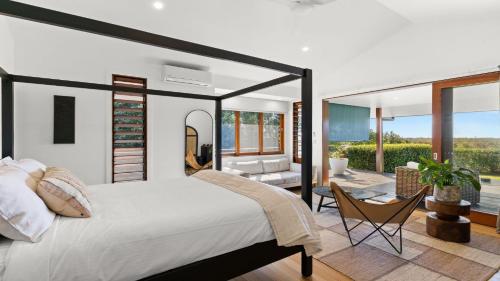 a bedroom with a large bed and a living room at Cape Vue Studio 4 in Byron Bay