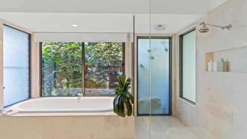 a bathroom with a bath tub and a window at Cape Vue Studio 4 in Byron Bay