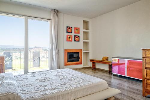 ein Schlafzimmer mit einem Bett und einem Kamin in der Unterkunft Villa Il Poggino - Modern House in Foiano della Chiana