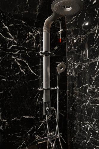 a shower in a bathroom with a black marble wall at Residenza di Fedralia in Nafplio