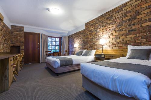 a hotel room with two beds and a brick wall at Montville Mountain Inn in Montville