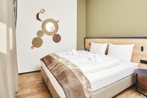 a bedroom with a large bed with white sheets at HOMEBOUND APARTMENTS Bad Goisern - contactless check-in in Bad Goisern