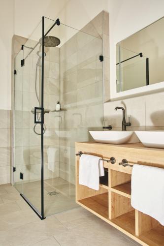 a bathroom with a glass shower and a sink at HOMEBOUND APARTMENTS Bad Goisern - contactless check-in in Bad Goisern
