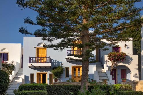 a white house with a tree in front of it at Nefeli Hotel Leros in Agia Marina
