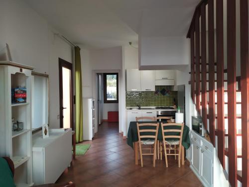 uma cozinha com mesa e cadeiras num quarto em Ajò Faci a Mari em Capoterra