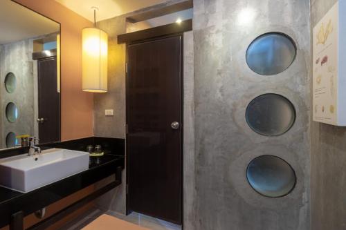 a bathroom with a sink and a mirror at Sila at Hua Hin Serviced Apartment & Hotel in Hua Hin