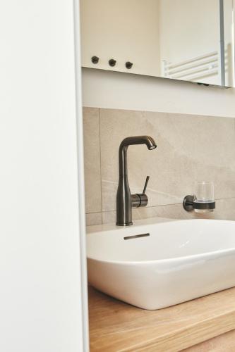 a sink with a faucet in a bathroom at HOMEBOUND APARTMENTS Bad Goisern - contactless check-in in Bad Goisern