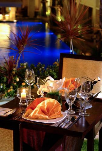 a table with a plate of food and wine glasses at Aston Kuta Hotel and Residence in Kuta