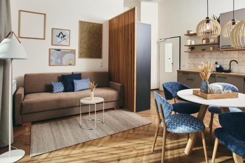 a living room with a couch and a table and chairs at HOMEBOUND APARTMENTS Bad Goisern - contactless check-in in Bad Goisern