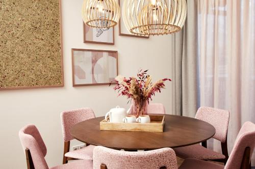 a dining room with a table with pink chairs at HOMEBOUND APARTMENTS Bad Goisern - contactless check-in in Bad Goisern