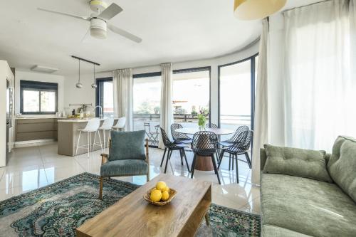 a living room with a couch and a table at Chic 3BR Apt w Balcony & Parking by Tel Aviv Port by Sea N' Rent in Tel Aviv
