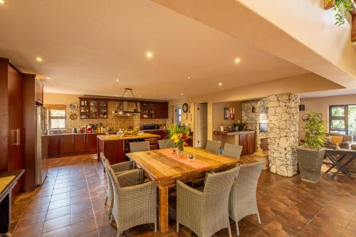 Una cocina y un comedor con mesa y sillas de madera. en Gecko Ridge, en Swakopmund