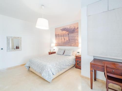 Habitación blanca con cama y escritorio en Cubo's Beach & Golf Marbella, en Marbella