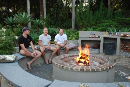 a group of men sitting around a fire pit at Tehillah Guest House in George