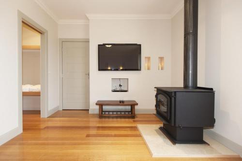 a living room with a stove and a tv at Grampians Manor House in Halls Gap