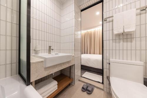 e bagno con lavandino, servizi igienici e vasca. di ARA Hotel a Seul