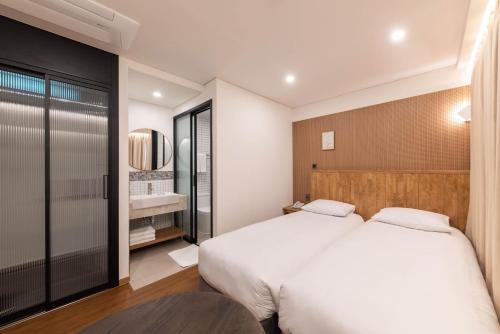 a bedroom with two beds and a table at ARA Hotel in Seoul