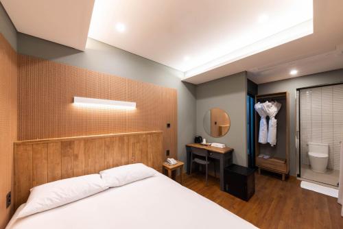 1 dormitorio con 1 cama y baño con aseo en ARA Hotel, en Seúl