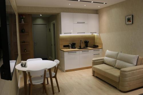 古道里的住宿－New Gudauri F4，带沙发和桌子的客厅以及厨房。
