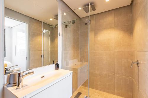 uma casa de banho com um lavatório e um chuveiro em Beautiful Family Apartment with amazing views @ 16 on Bree em Cidade do Cabo