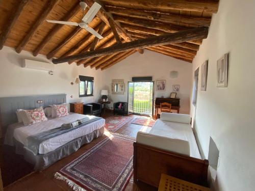 a bedroom with two beds and a ceiling fan at La Guzmana de Ronda in Ronda