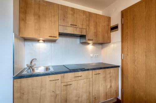 eine Küche mit Holzschränken und einem Waschbecken in der Unterkunft Kammerhof Apartment Apfel in Lana