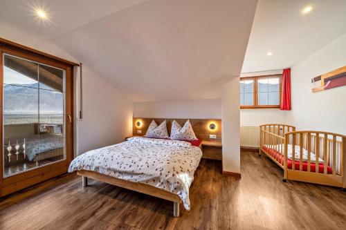 Schlafzimmer mit einem Bett und einem Fenster in der Unterkunft Kammerhof Apartment Apfel in Lana