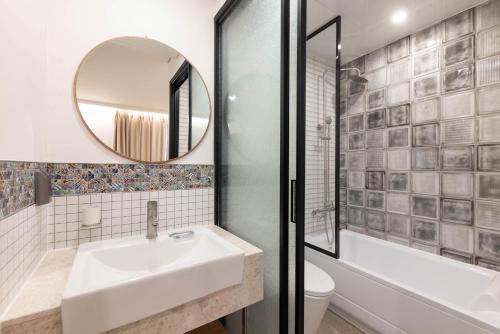 a bathroom with a sink and a tub and a mirror at ARA Hotel in Seoul