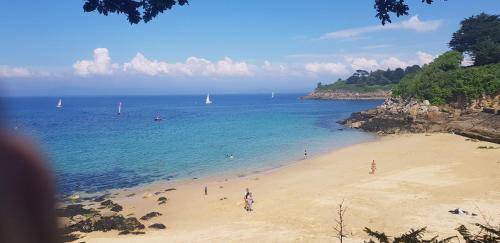 um grupo de pessoas numa praia perto da água em Maison Papillons em Plomodiern