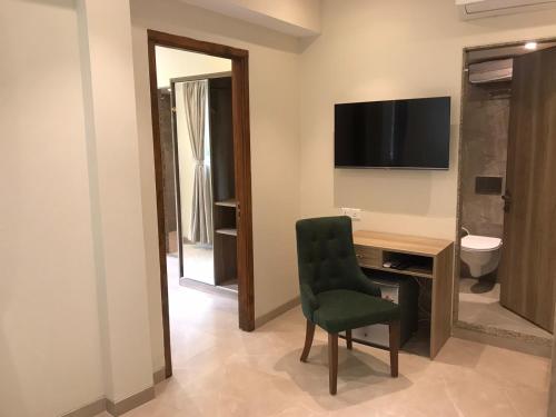 Zimmer mit einem Schreibtisch, einem Stuhl und einem TV in der Unterkunft Hotel Flora Inn Male Maldives in Male City