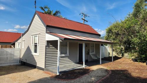 a small white house with a red roof at 'Pickett's Cottage' - Circa 1868 - Oldest in Knox! in Boronia