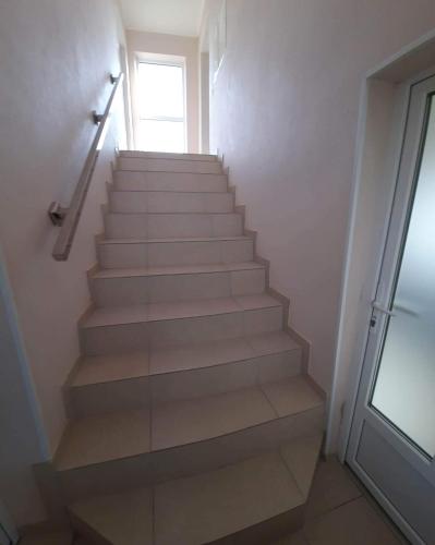 a staircase in a room with a glass door at Petite Chambre in Velyatyn