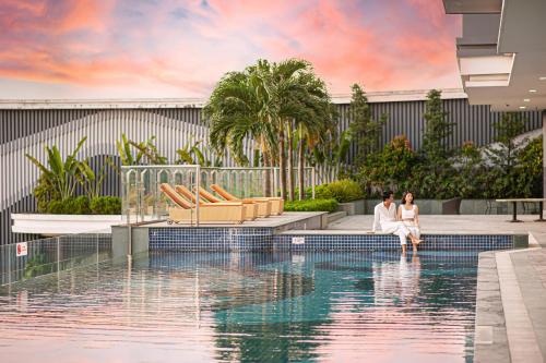 duas mulheres sentadas numa piscina num resort em The Reed Hotel em Ninh Binh