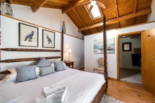 Un dormitorio con una cama grande en una habitación con techos de madera. en Quinta Lagares, en Penacova