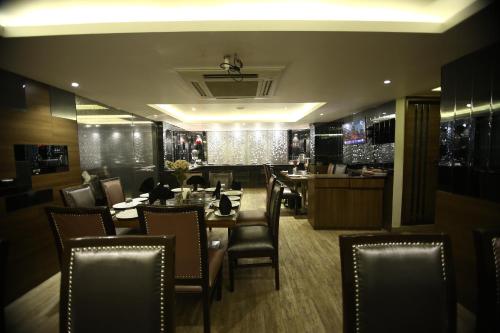 ein Restaurant mit einem Esszimmer mit Tischen und Stühlen in der Unterkunft Hotel JRD Exotica in Neu-Delhi