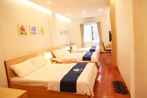 una habitación de hotel con tres camas y un sofá en Little Nha Trang Hotel, en Nha Trang