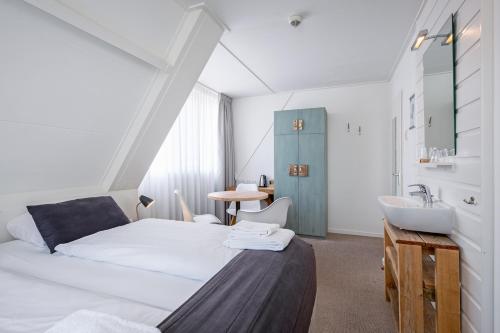 a bedroom with a white bed and a sink at B&B Boutique Hotel De Waal in De Waal