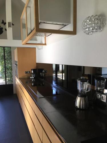 une cuisine avec un comptoir noir dans une pièce dans l'établissement Belle maison dans un village de charme, à Moisson