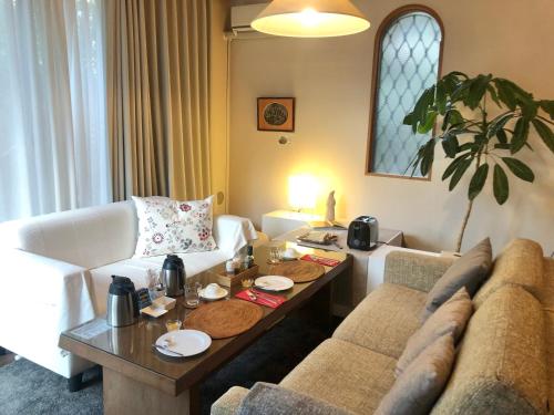 a living room with a couch and a table at B&B Kumakara in Kamakura