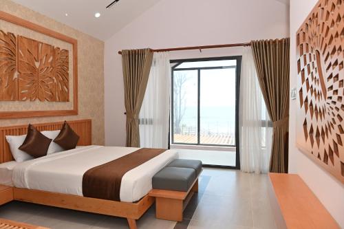 1 dormitorio con cama y ventana grande en Trân Châu Beach & Resort, en Bà Rịa
