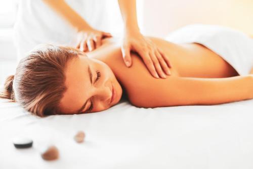 a woman getting a massage on a bed at EUROPÄISCHER HOF Bad Gastein in Bad Gastein