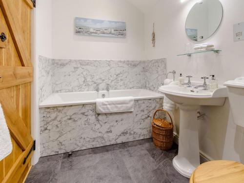 a white bathroom with a tub and a sink at Middle Mistal in Stainburn