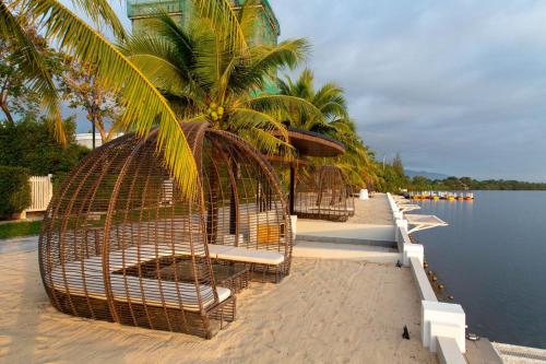 a row of bird cages on a beach next to the water at Castle Bayview Resort & Spa in Kampot