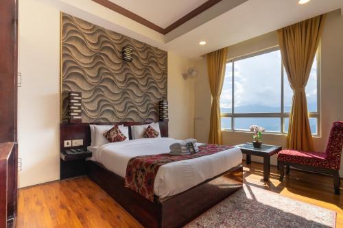 um quarto de hotel com uma cama e uma cadeira em HOTEL SHINKHAM GRAND em Gangtok